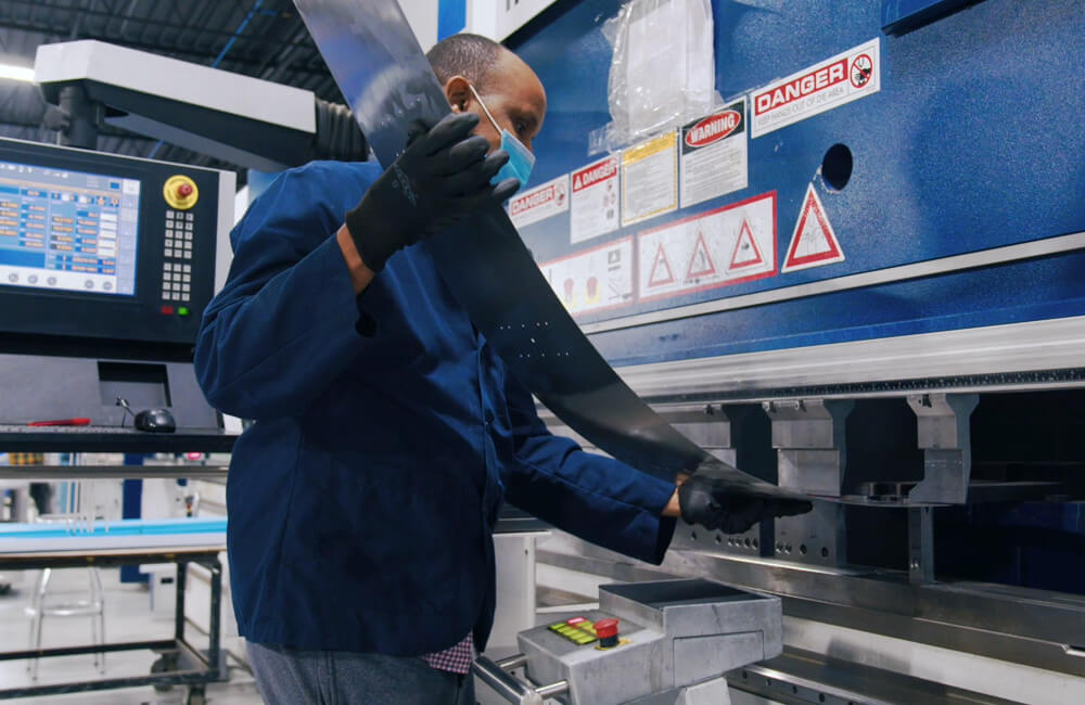 Worker operating a CNC brake press machine