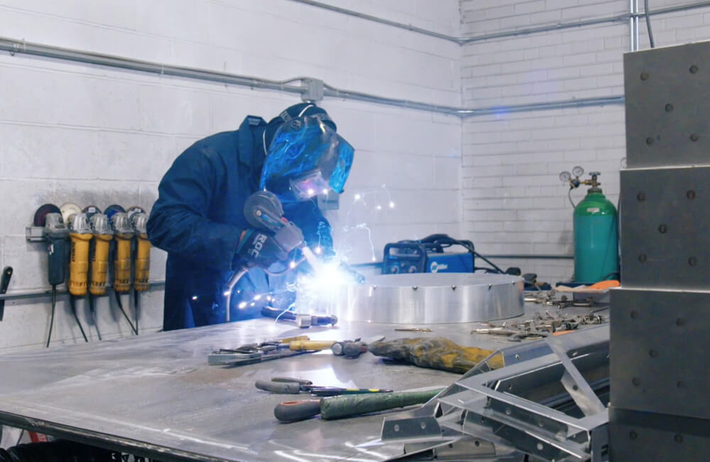 Man in welding metal in a manufacturing plant